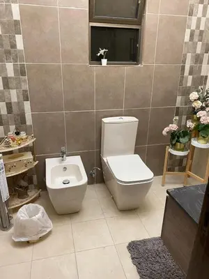 a bathroom with a toilet and a sink and a window at Amman Apartment 123 in Amman