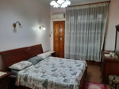 a bedroom with a bed and a desk and a window at 909 apartment in Amman