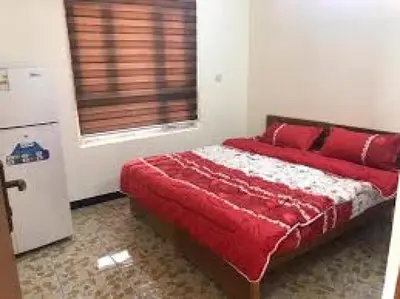 a bedroom with a bed with red pillows and a window at asfouer Hostel in Muqbilah