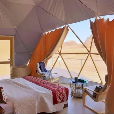a bedroom with a tent with a view of the desert at Nova Luxury Camp in Wadi Rum