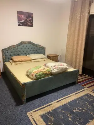 a bed with a blue headboard in a bedroom at University Castle in Amman