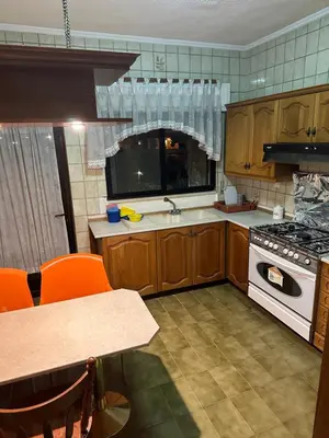 a kitchen with wooden cabinets and a white stove top oven at University Castle in Amman