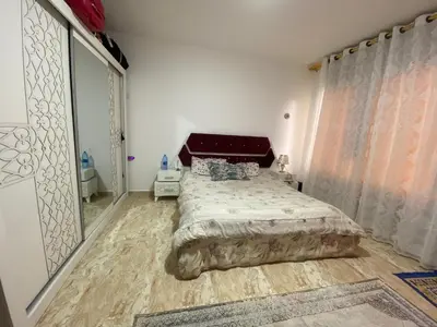 a bedroom with a bed and a large window at zainab bedouin house in Petra
