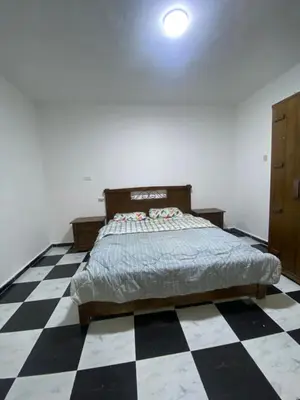 a bedroom with a bed and a checkered floor at zainab bedouin house in Petra