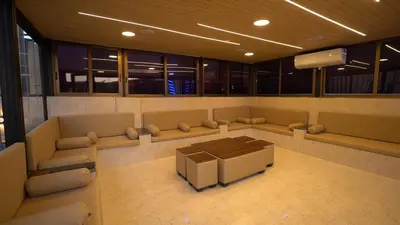a room with couches and a table and a tv at LeRose Villa in Ash Shāghūr