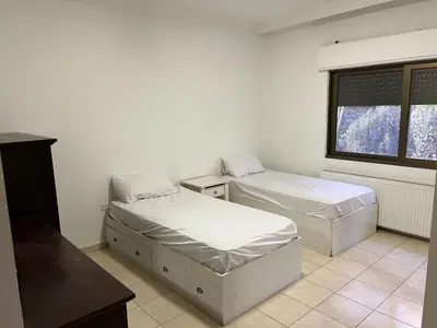 a room with two beds and a window at On the street 3 Room in Amman