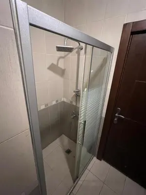 a shower with a glass door in a bathroom at On the street 3 Room in Amman