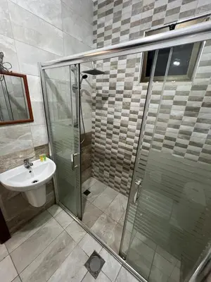 a bathroom with a glass shower and a sink at On the street 3 Room in Amman