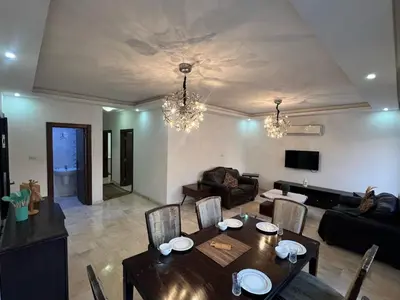 a living room with a table and a couch at On the street 3 Room in Amman