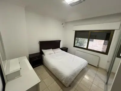a small bedroom with a white bed and a window at On the street 3 Room in Amman