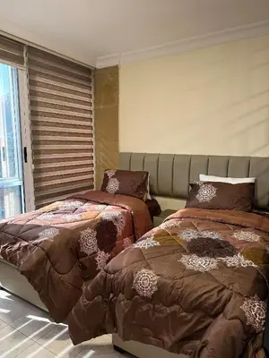 two beds sitting next to each other in a bedroom at gardens studio استوديو الجاردنز 401 in Amman