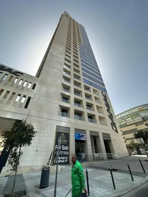 a man walking in front of a tall building at One Bedroom Damac Tower 8th Floor Boulevard Abdali غرفة وصالة فاخرة - برج داماك العبدلي البوليفارد الطابق الثامن in Amman