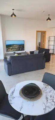 a living room with a couch and a table at One Bedroom Damac Tower 8th Floor Boulevard Abdali غرفة وصالة فاخرة - برج داماك العبدلي البوليفارد الطابق الثامن in Amman