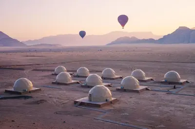 a group of hot air balloons flying over the desert at جمال رم in Aqaba