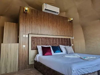 a bedroom with a large bed with a wooden headboard at جمال رم in Aqaba