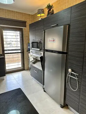 a kitchen with a stainless steel refrigerator and a microwave at shafa badran شفا بدران ام الحجير in Amman