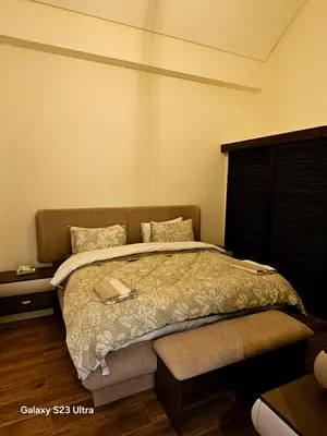 a bedroom with a bed with a book on it at C33 Samarah Resort LOFT apartment in Sowayma