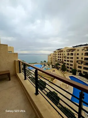 a balcony with a view of the ocean and buildings at C33 Samarah Resort LOFT apartment in Sowayma