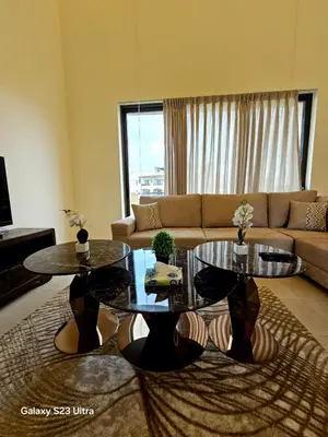 a living room with two tables and a couch at C32 Samarah Resort LOFT apartment in Sowayma