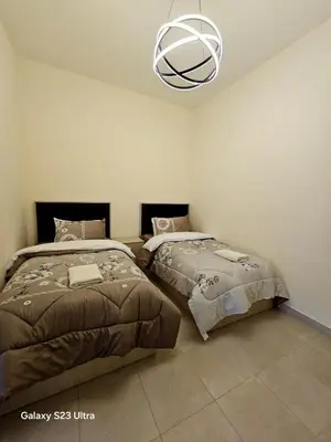 two beds sitting next to each other in a bedroom at C32 Samarah Resort LOFT apartment in Sowayma