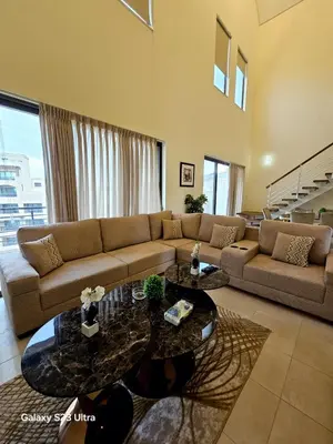 a living room with a couch and a table at C32 Samarah Resort LOFT apartment in Sowayma