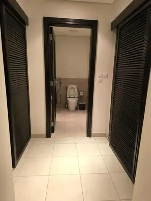 a bathroom with a toilet in a room with black doors at C04 Samarah Resort One Bedroom apartment in Sowayma