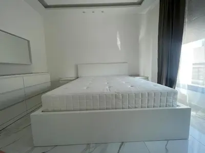 a white bedroom with a bed in a room at Premium 1BR Furnished Apartment in Amman