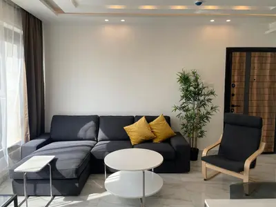 a living room with a blue couch and two chairs at Premium 1BR Furnished Apartment in Amman