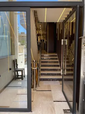 a glass door leading into a building with stairs at Premium 1BR Furnished Apartment in Amman