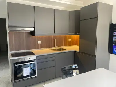 a kitchen with gray cabinets and a sink and a stove at Premium 1BR Furnished Apartment in Amman