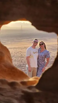 a man and a woman standing in front of the ocean at Wadi Rum Kenan Camp in Wadi Rum