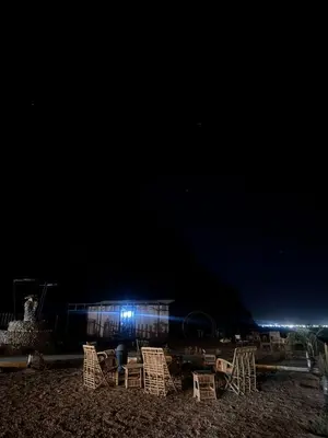 a group of chairs on the beach at night at Wadi Rum Kenan Camp in Wadi Rum
