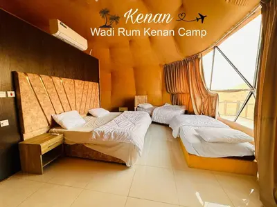 a bedroom with two beds and a window at Wadi Rum Kenan Camp in Wadi Rum