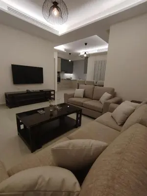 a living room with a couch and a coffee table at Newly Built apartment Deir Ghbar in Amman