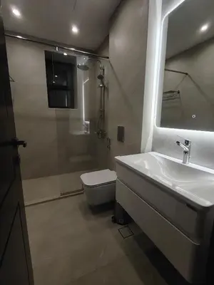 a bathroom with a sink and a toilet and a shower at Newly Built apartment Deir Ghbar in Amman