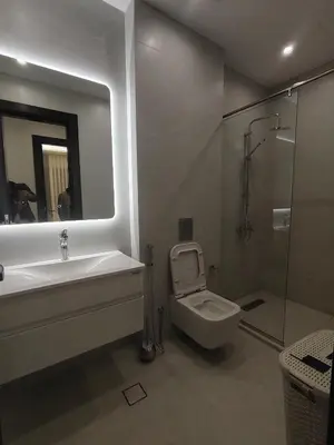 a bathroom with a toilet and a sink and a shower at Newly Built apartment Deir Ghbar in Amman