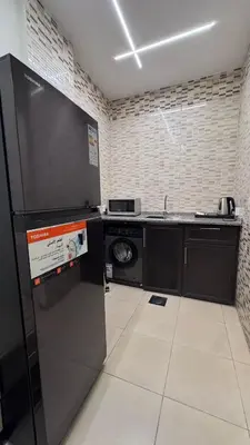 a kitchen with a black refrigerator and a dishwasher at يزن للاجنحة الفندقية in Aqaba