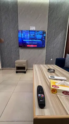 a remote control on a table in front of a tv at يزن للاجنحة الفندقية in Aqaba