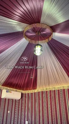 a stage with a purple curtain and a chandelier at Zain Wadi Rum Camp in Wadi Rum