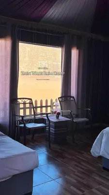 a bedroom with two beds and a window at Zain Wadi Rum Camp in Wadi Rum
