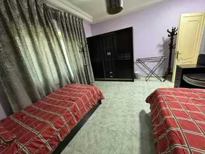 a bedroom with two beds and a window and a door at VOV House in At-Tafilah