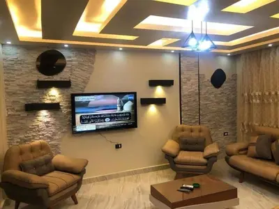 a living room with couches and a flat screen tv at VOV House in At-Tafilah
