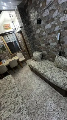a room with two beds and a stone wall at VOV House in At-Tafilah