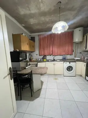a small kitchen with a table and a sink at zainab house in Amman