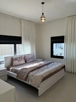 a bedroom with a large bed in a room with windows at Modern 2BR in Trendy Jabal AlWebdeh with View in Amman