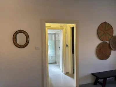 a hallway with a mirror on the wall and a mirrorphasis at Modern 2BR in Trendy Jabal AlWebdeh with View in Amman
