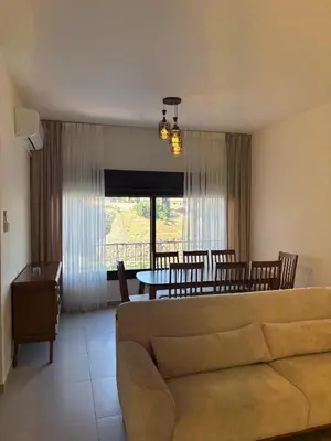 a living room with a couch and a table at Modern 2BR in Trendy Jabal AlWebdeh with View in Amman