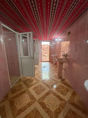 a bathroom with pink walls and a red ceiling at Wadi Rum safari camp in Wadi Rum
