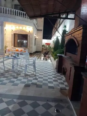 a patio with a table and chairs on a checkered floor at الزئبق فارم in Maḩaţţat al Ḩafīf