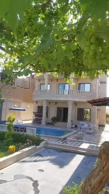 a large house with a swimming pool in front of it at الزئبق فارم in Maḩaţţat al Ḩafīf